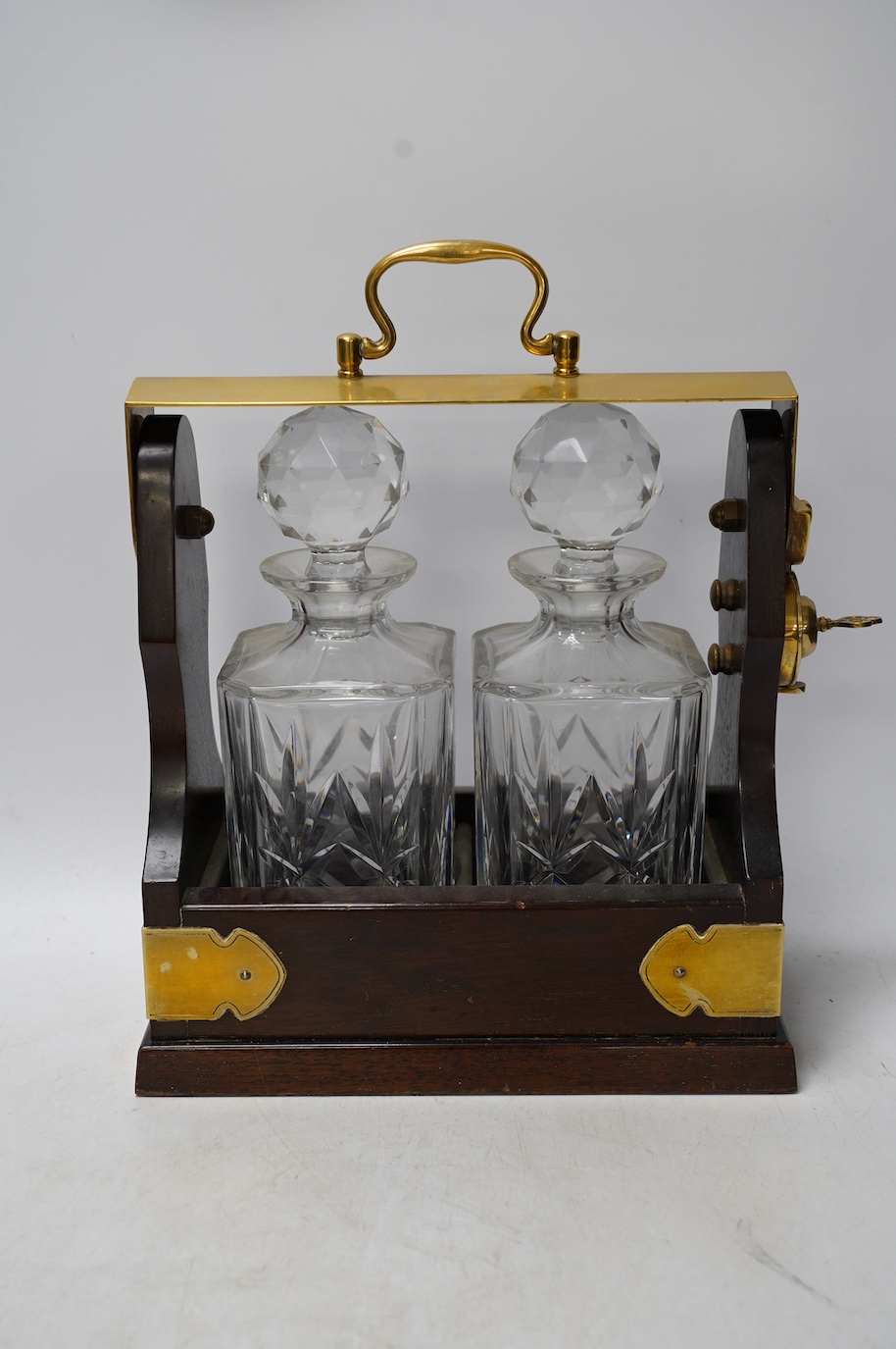 A brass mounted two bottle tantalus and three glass decanters / jugs, largest 32cm high. Condition - fair